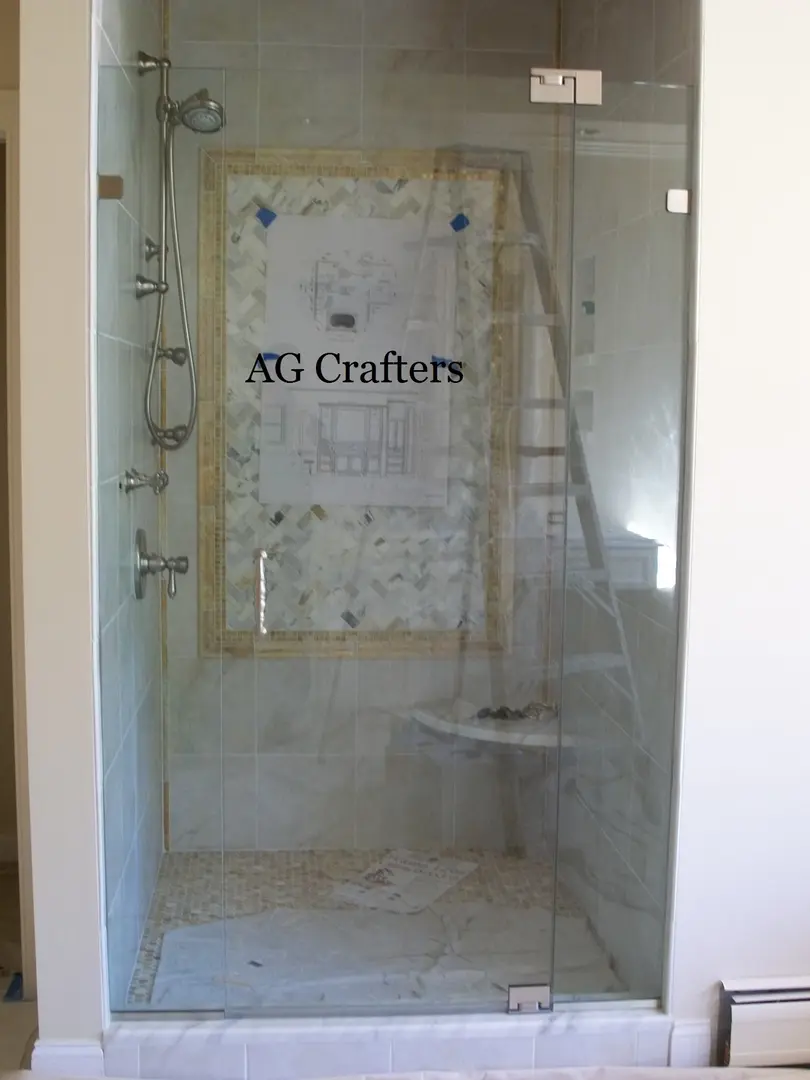 Glass shower enclosure with wall design inside.