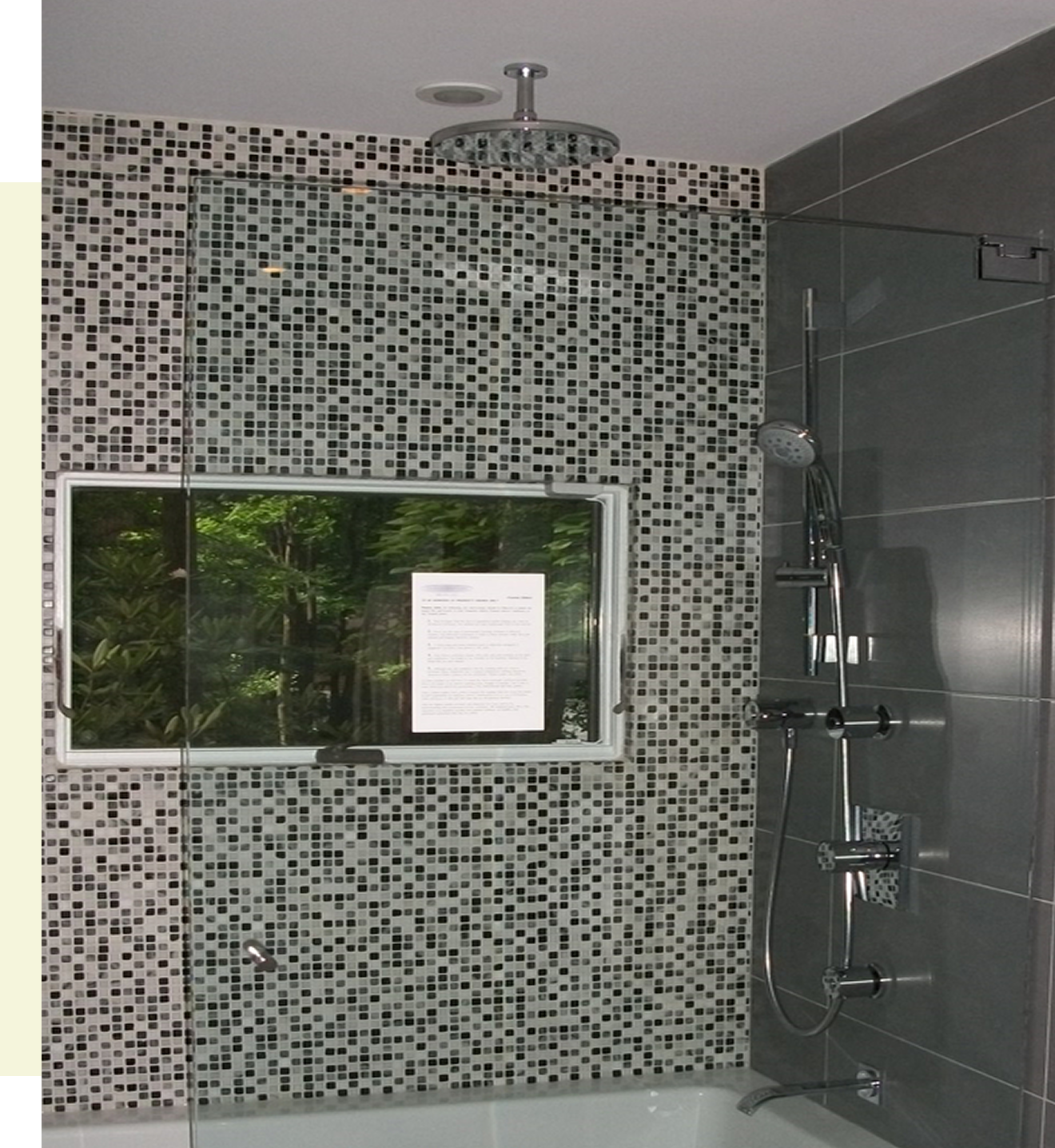 Modern shower with mosaic tile wall.