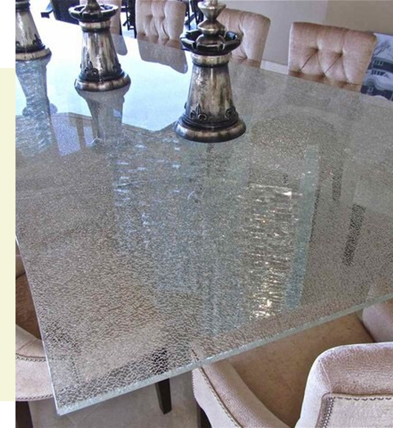 Glass dining table with decorative silver candlesticks.