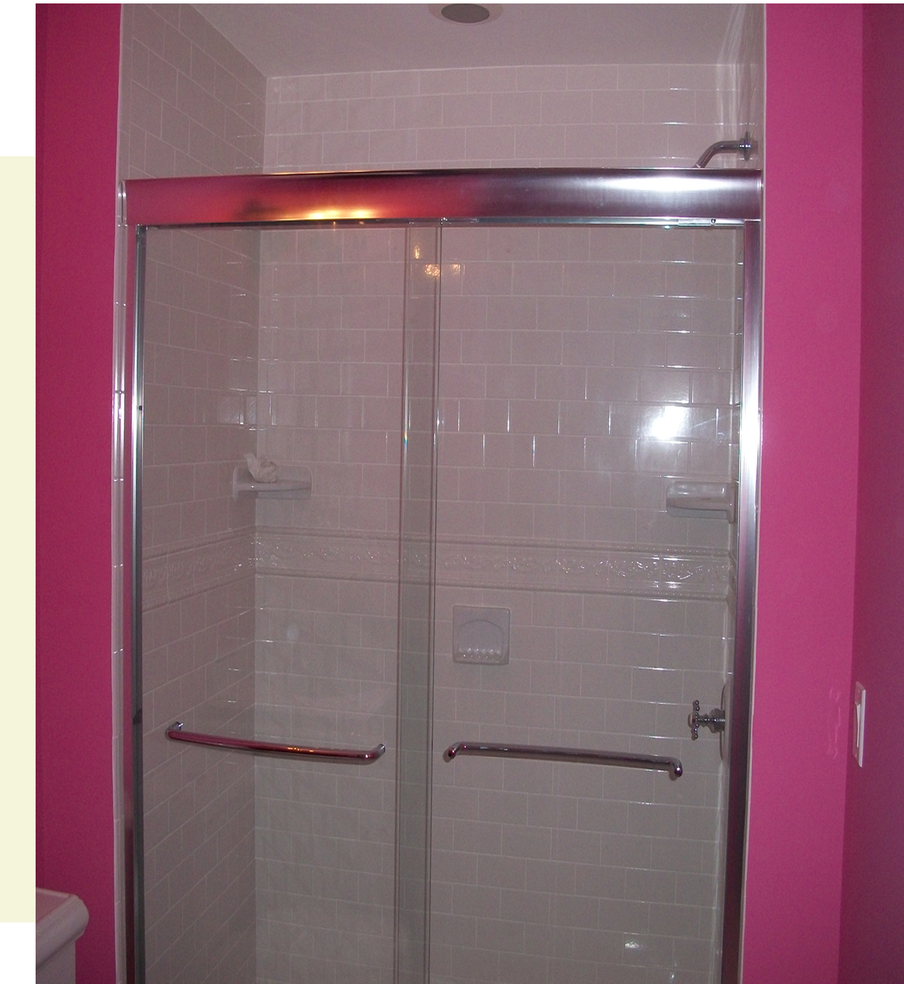 Glass shower with bright pink walls.