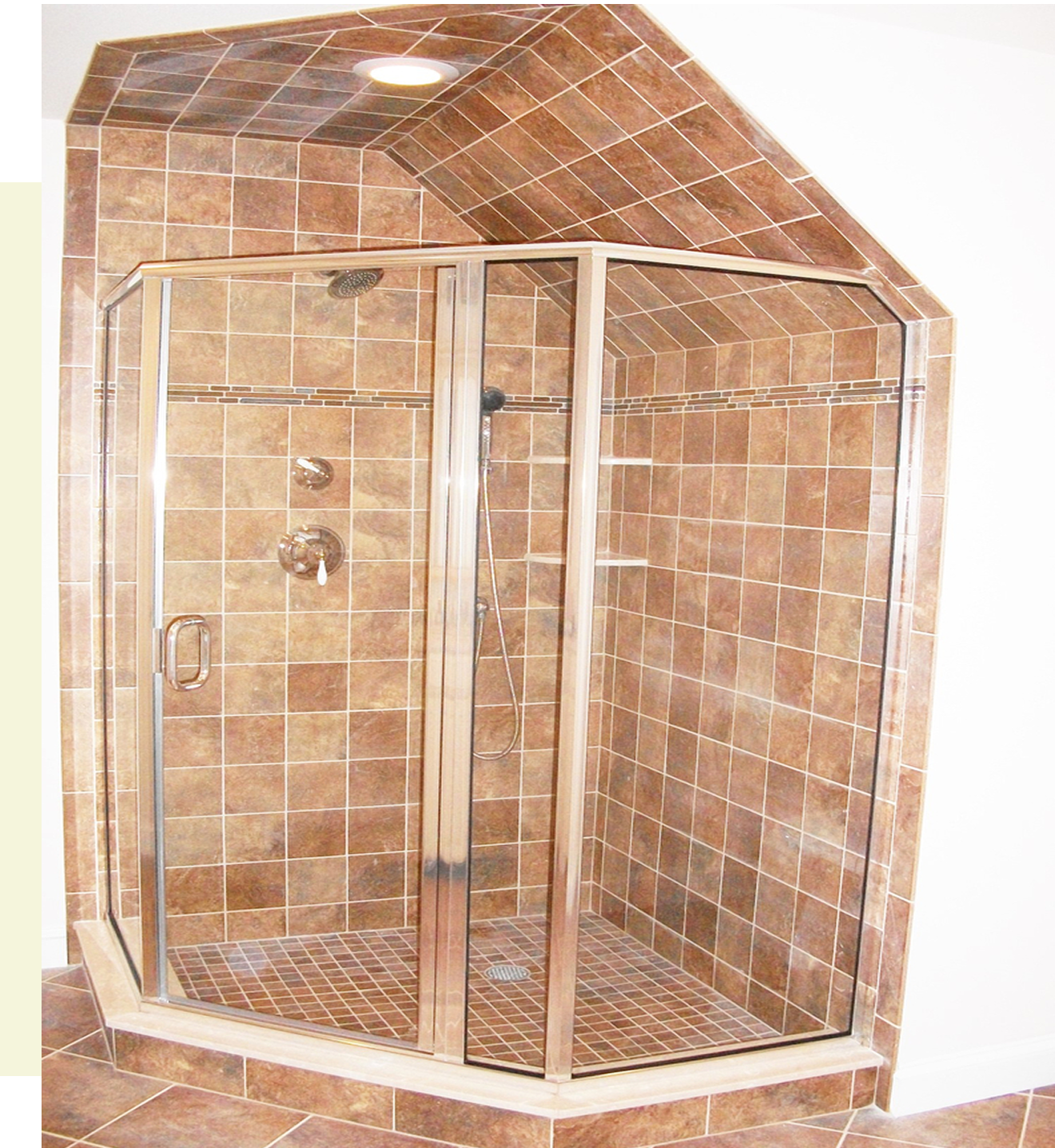 Brown tiled shower with glass enclosure.